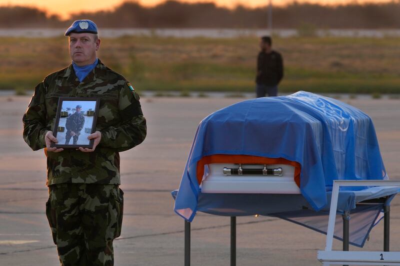 An Irish UN peacekeeper stands next to the coffin of Pvt Sean Rooney, who was killed in 2022. AP