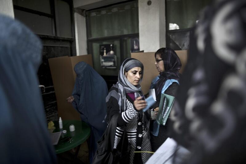 An Afghan woman, center, walks to cast her ballot at a polling station in Kabul, Afghanistan, Saturday, April 5, 2014. Afghan voters lined up for blocks at polling stations nationwide on Saturday, defying a threat of violence by the Taliban to cast ballots in what promises to be the nation’s first democratic transfer of power. Muhammed Muheisen / AP