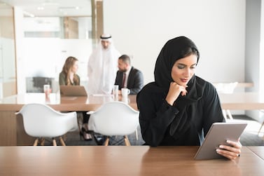 Candid portrait of Arab businesswoman holding digital tablet at desk. Photo: Getty Images
