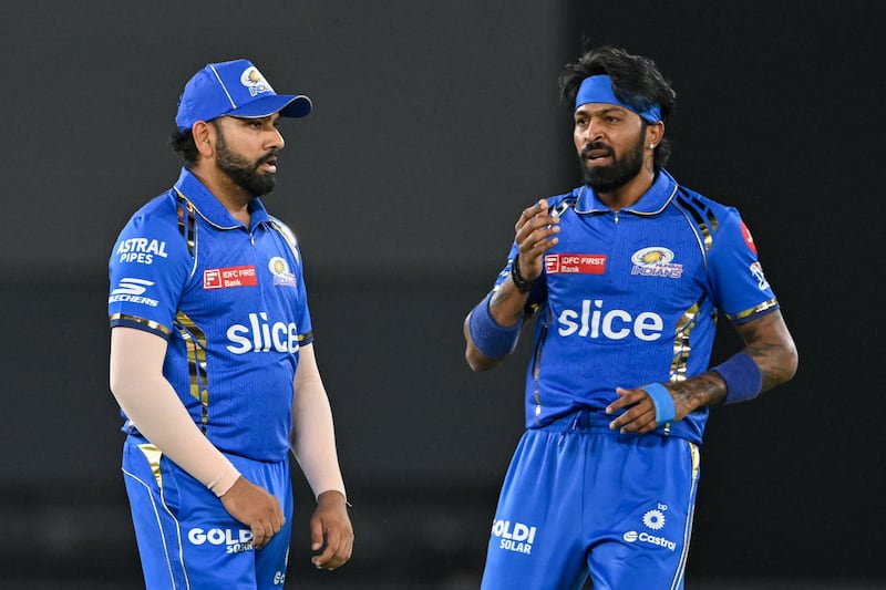 Mumbai Indians' captain Hardik Pandya and his teammate Rohit Sharma (L) gesture during the Indian Premier League (IPL) Twenty20 cricket match between Gujarat Titans and Mumbai Indians at the Narendra Modi Stadium in Ahmedabad on March 24, 2024.  (Photo by Punit PARANJPE  /  AFP)  /  -- IMAGE RESTRICTED TO EDITORIAL USE - STRICTLY NO COMMERCIAL USE --