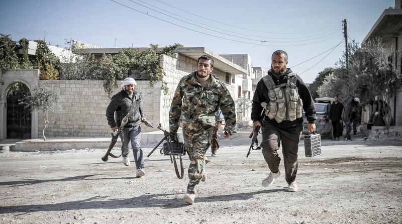 Rebels defending the town run towards a forward fighting position as the battle for Maaret Al Numan, in the southern Idlib province, continued between rebel forces and the Syrian government troops, on November 19, 2012. John Cantlie/AFP Photo