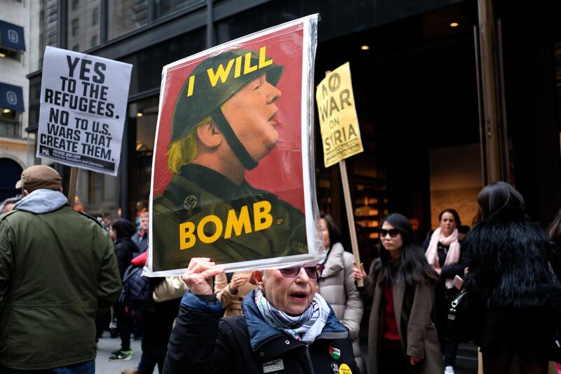 Anti-war protesters shout slogans against US President Donald Trump during a demonstration in front of the Trump Tower in New York on April 7, 2017, to protest the US air strike in Syria.
The United States on April 7 warned it was ready to hit Syria again after targeting an air base in a strike that infuriated Moscow and fueled calls for a new diplomatic push to end the six-year war.

 / AFP PHOTO / Jewel SAMAD