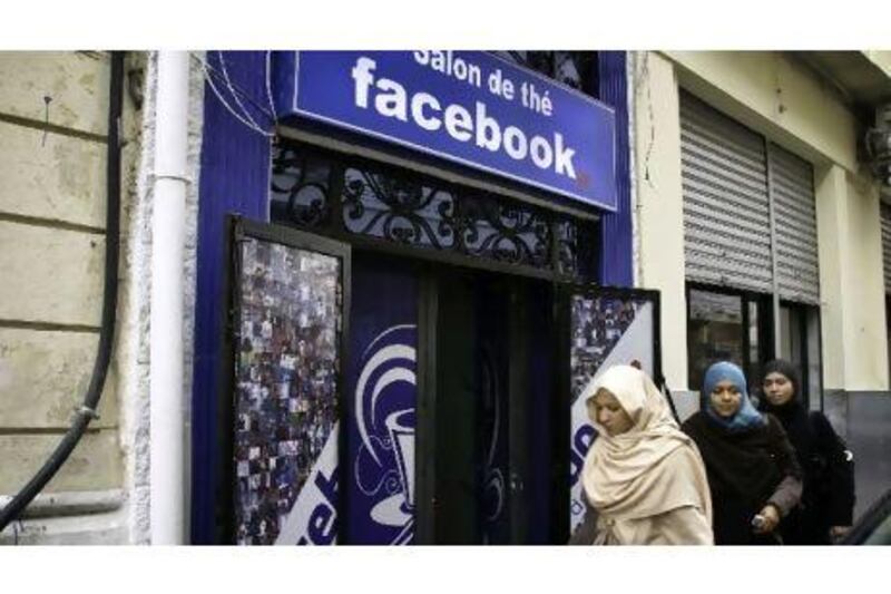 Women walk past the Facebook Cafe in the centre of Tunis.
