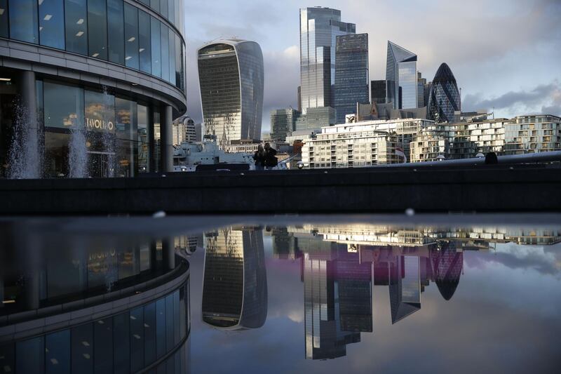 A picture shows the office buildings of the City of London reflected in a puddle in central London on November 3, 2020 as England prepares to head into a second coronavirus lockdown in an effort to combat soaring infections. England will head into a second national lockdown on November 5. / AFP / Hollie Adams
