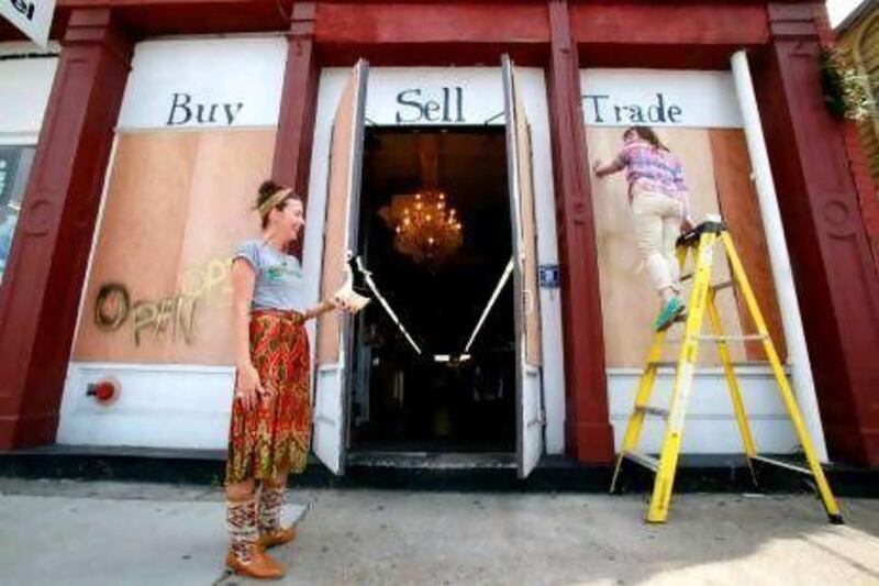 Magazine Street, New Orleans retail employees prepare for Tropical Storm Isaac by putting plywood over their windows.