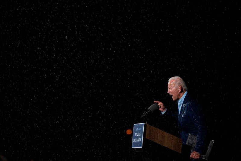 TOPSHOT - Former vice-president and Democratic presidential nominee Joe Biden delivers remarks in the rain during a Drive-In event in Tampa, Florida, on October 29, 2020. / AFP / JIM WATSON

