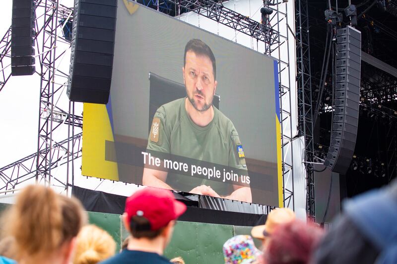 Festivalgoers watch a recorded message from the President of Ukraine, Volodymyr Zelenskyy. EPA