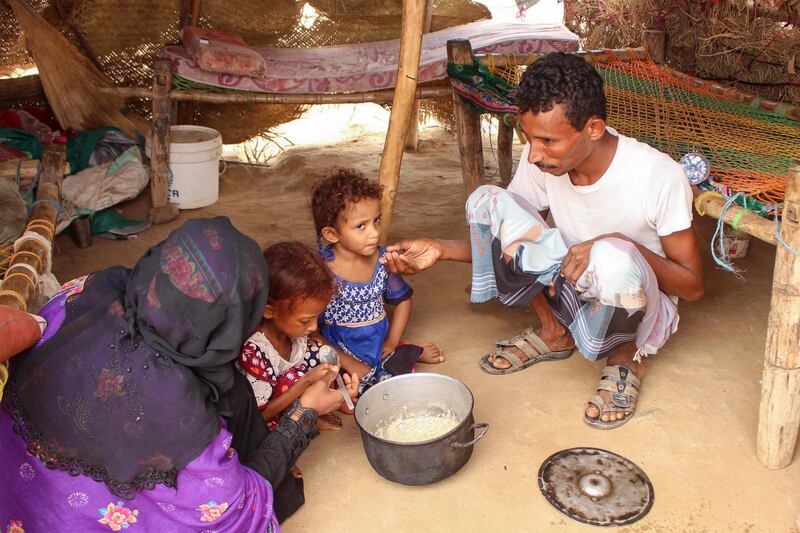 Samar Ali Jaidi (second from left), a seven-year-old girl suffering from malnutrition, eats with her family at a make-shift camp for displaced Yemenis, September 28, 2019. AFP