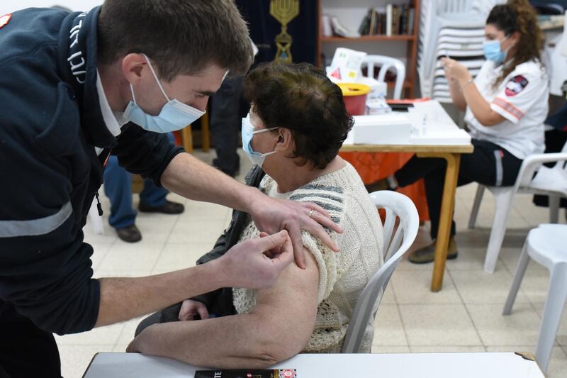 An Israeli woman receives a coronavirus vaccine at a temporary clinic set up by the Magen David Adom emergency services.