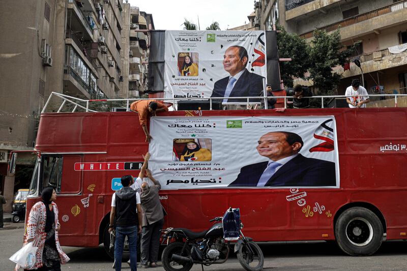 Supporters hang a campaign banner for President Abdel Fattah El Sisi on a bus in Cairo for Egypt's presidential elections this week. AFP