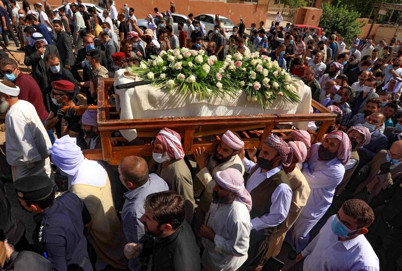 Iraqi Yazidi men carry the casket of Baba Sheikh Khurto Hajji Ismail during his funeral procession in the Iraqi town of Sheikhan. AFP