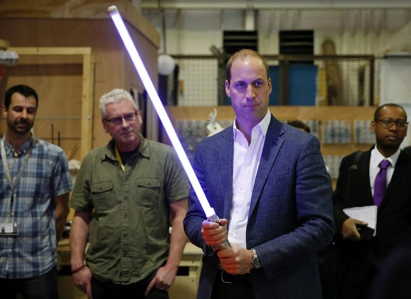 The Duke of Cambridge, Prince William holds a light sabre during a visit to the Star Wars film set on April 19, 2016. Courtesy Adrian Dennis/AFP