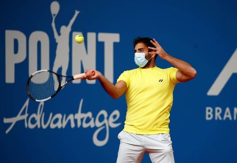 Benjamin Hassan, a German ATP player wears a face mask as he warms up for an exhibition tennis match played without spectators and broadcasted by remote controlled cameras, during the spread of the coronavirus disease in a tennis academy in Hoehr-Grenzhausen, near Koblenz, Germany. Reuters