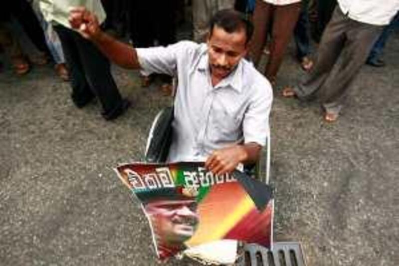 A disabled supporter of the opposition party Democratic National Alliance holds a poster of Sri Lankan army General Sarath Fonseka during a protest calling for the General's release, in Colombo March 23, 2010. The court martial of the General, held at the navy headquarters in Colombo, was adjourned on March 17 until next month after lawyers for the army commander challenged the legitimacy of the court and opposed the choice of the members of the military tribunal. Sri Lanka's parliamentary elections will be held on April 8.  The sign reads "Only one challenge." REUTERS/Andrew Caballero-Reynolds  (SRI LANKA - Tags: POLITICS CIVIL UNREST ELECTIONS) *** Local Caption ***  COL01_SRILANKA-_0323_11.JPG *** Local Caption ***  COL01_SRILANKA-_0323_11.JPG