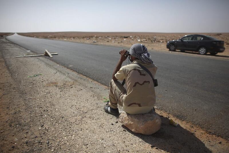 A rebel fighter guards the highway leading to Bani Walid, at a checkpoint in Wadi Dinar, Libya, in 2011. Times have changed since then. (Alexandre Meneghini / AP)