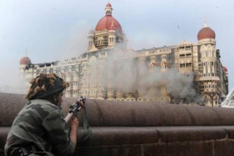 (FILES) This photograph taken on November 29, 2008 shows an Indian soldier aiming his weapon towards The Taj Mahal Hotel in Mumbai. A Pakistani man on trial in India over last year's Mumbai attacks pleaded guilty on July 20, 2009, admitting his part in the atrocity for the first time, television reports said.   AFP PHOTO/FILES/PEDRO UGARTE