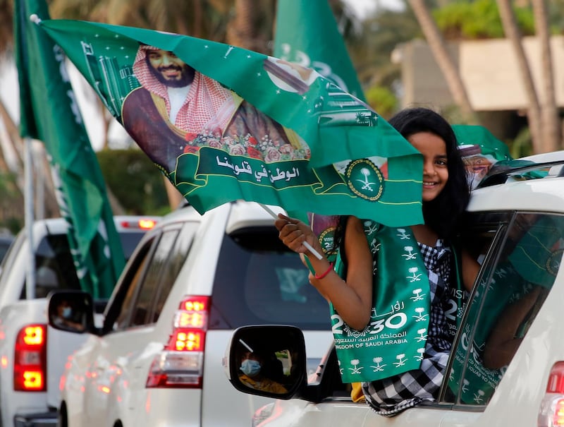 A Saudi girl waves a national flag emblazoned with an image of Saudi Crown Prince Mohammed bin Salman in Jeddah. AP Photo
