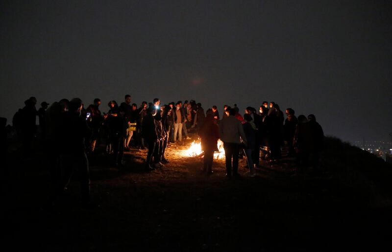 A crowd gathers round a bonfire for Charshanbeh Suri, in Tehran. The festival is also marked by fortune telling and smashing pots for good luck. EPA
