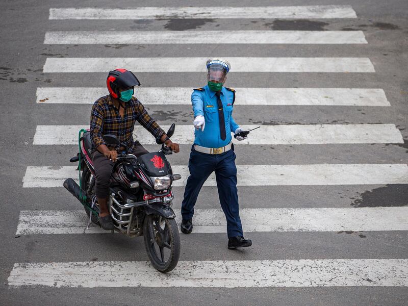 A traffic police officer stops a motorcyclist during lockdown in Kathmandu, Nepal.  EPA