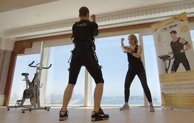 An instructor takes a client wearing EMS gear through exercises. Courtesy: Fit in Time