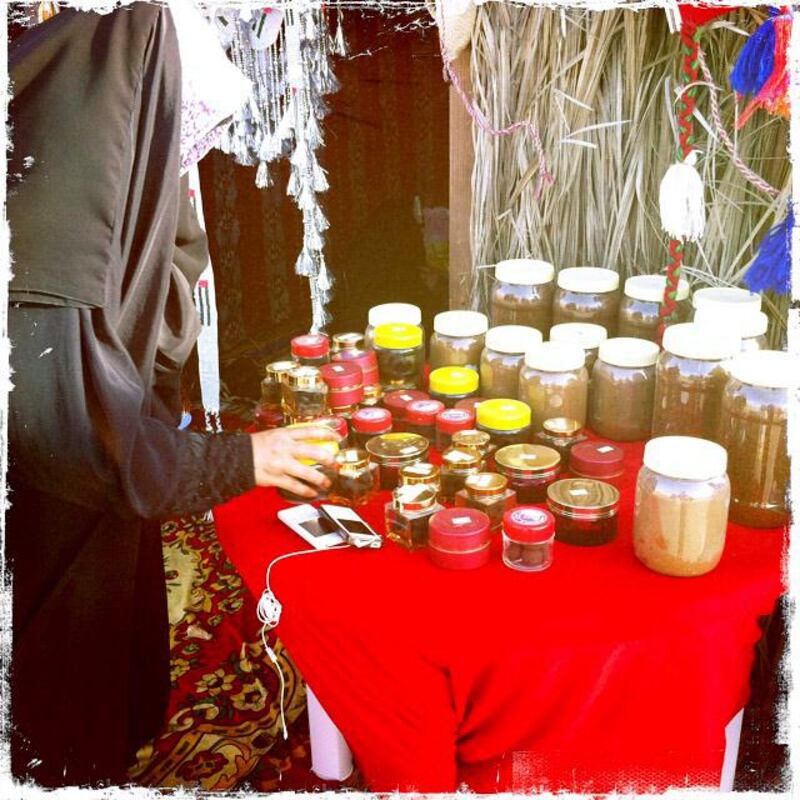 Day trip with friends to the Western Region and the Mazayin Dhafra Camel Festival, 220 kms west of Abu Dhabi on December 20, 2013.  A merchant organizes her wares at the traditional souk.  Picture taken with the Hipstamatic app for the iPhone. Liz Claus / The National