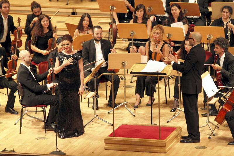 In this Sept. 11, 2016 photo Rasha Rizk thanks the audience after her soprano performance in a concert of the Syrian Expat Philharmonic Orchestra in the Concert House in Berlin's Gendarmenmarkt. The Orchestra consists entirely of professional musicians who fled civil war in their homeland to seek refuge in Europe. (AP Photo/Jona Kallgren)