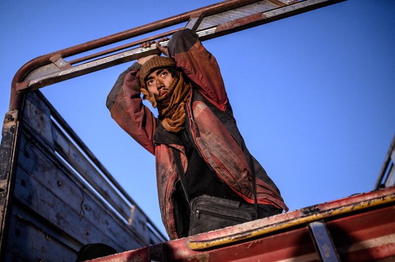 A man suspected of being an ISIS fighter  leans on the back of a lorry as he waits to be searched by members of the Syrian Democratic Forces in Baghouz, Syria. AFP