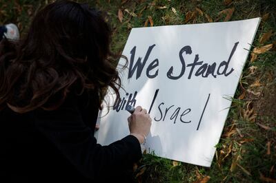 A woman writes on a poster during a rally outside of the Israeli embassy in Washington. Getty Images / AFP