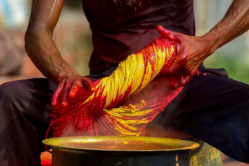 A worker dyes a batch of Kalawa threads in Allahabad. AFP
