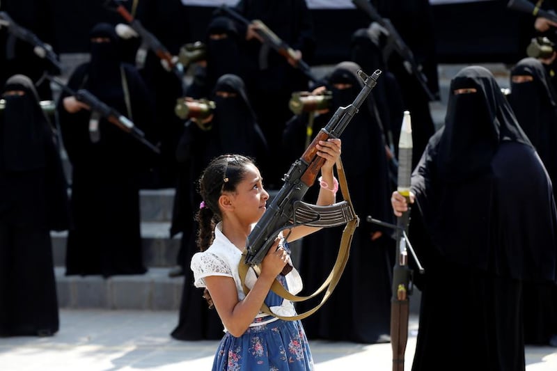 A girl holds a rifle in front of women during a parade in Sanaa, Yemen on September 6, 2016. The easy access to weapons in Yemen puts children and innocent bystanders in harm's way. Khaled Abdullah/Reuters