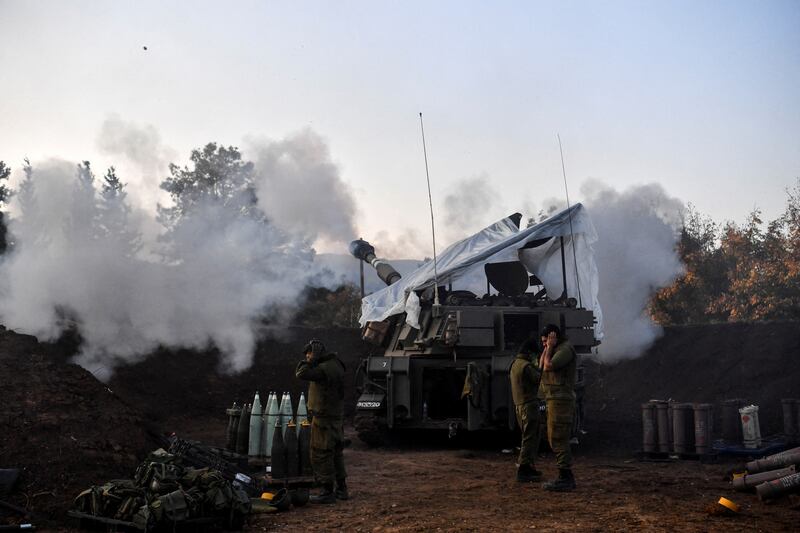 Israeli soldiers stand by as a mobile artillery unit fires across the border with Lebanon. Reuters