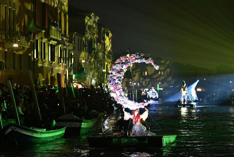 Artists perform during the 'Tutta colpa della Luna' or 'Blame the Moon' festivities down the Rio di Cannaregio, one of Venice's famed canals on February 16, 2019.  Venice began its annual Carnival festivities with a floating, night-time parade starting more than two weeks of celebrations to mark 50 years since man first walked on the moon. / AFP / Vincenzo PINTO
