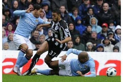 Manchester City's Nigel De Jong (R) and Carlos Tevez challenge Newcastle's Hatem Ben Arfa on October 3, 2010. Reuters