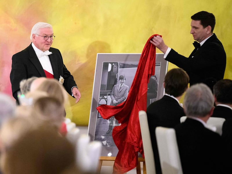 Mr Steinmeier, left, with a present for King Charles, a photo of him taken during a visit to Germany in his youth. AFP