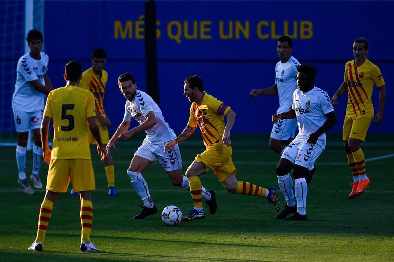 Lionel Messi runs with the ball during a friendly match between Barcelona and Gimnastic at the Johan Cruyff stadium. AFP