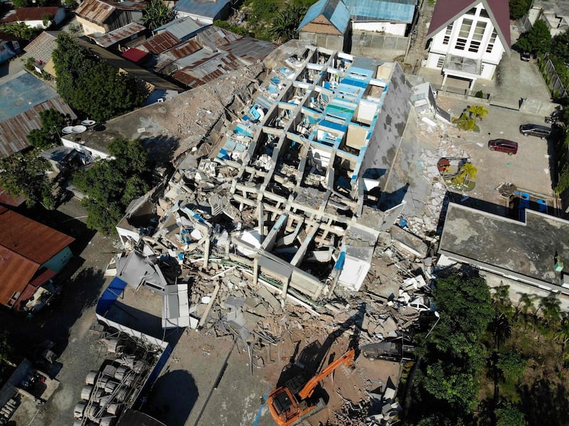 An earth remover works to clear debris from the collapsed Roa Roa hotel in Palu. AFP