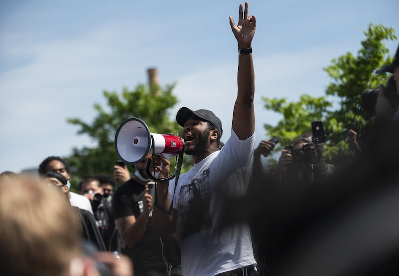 A man speaks into a megaphone as a crowd marches outside US Bank Stadium to protest against the death of George Floyd in Minneapolis. Getty Images