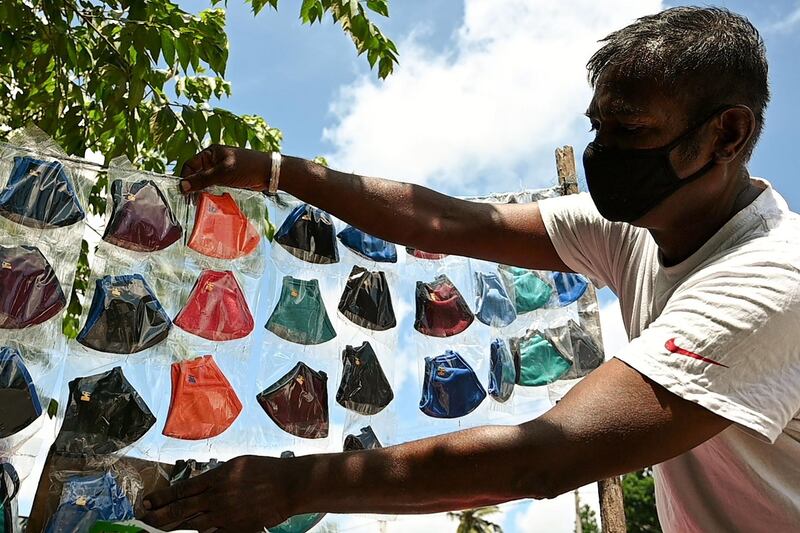 A street vendor wearing a facemask as a preventative measure against  Covid-19  sells face masks in Piliyandala, a suburb of Sri Lanka's capital Colombo. AFP