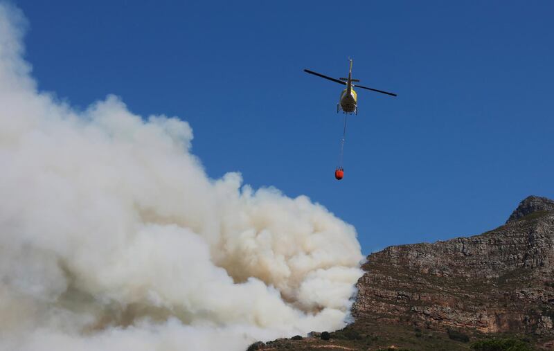 A helicopter drops water over the wildfire at Rhodes Memorial on Table Mountain, Cape Town. AP Photo