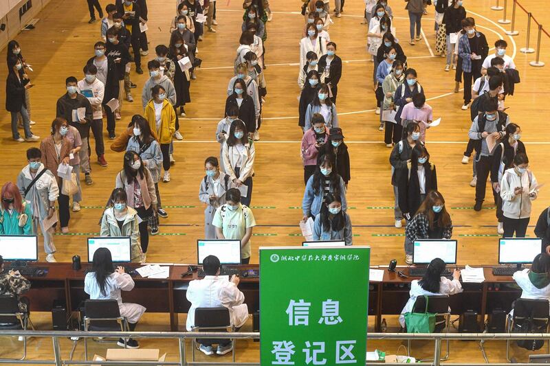 University students queue to receive the China National Biotec Group Covid-19 coronavirus vaccine at a university in Wuhan in China's central Hubei province. AFP