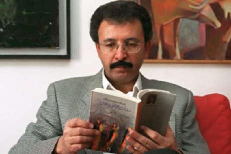 The poet Ibrahim Nasrallah holds his book <i>In the Name of the Mother and the Son</i> in Amman, Jordan, in this 2001 photo. His book <i>Time of White Horses</i> has been selected for the longlist of the Arab Booker prize.