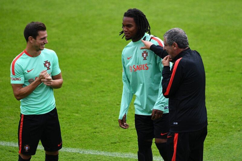 Portugal's coach Fernando Santos (R) jokes with Portugal's midfielder Renato Sanches (C) as defender Cedric Soares (L) looks on during a training session at the team's base camp in Marcoussis, south of Paris, on June 16, 2016, during the Euro 2016 football tournament. / AFP / FRANCISCO LEONG