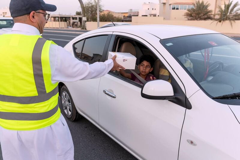 DUBAI, UNITED ARAB EMIRATES. 07 MAY 2019. Iftar meals being distributed to motorists by Marwan Al Hassan (wearing the baseball cap) and his team at the intersection of Al Asayel and 13D Str in Al Quoz 1. (Photo: Antonie Robertson/The National) Journalist: None. Section: National.