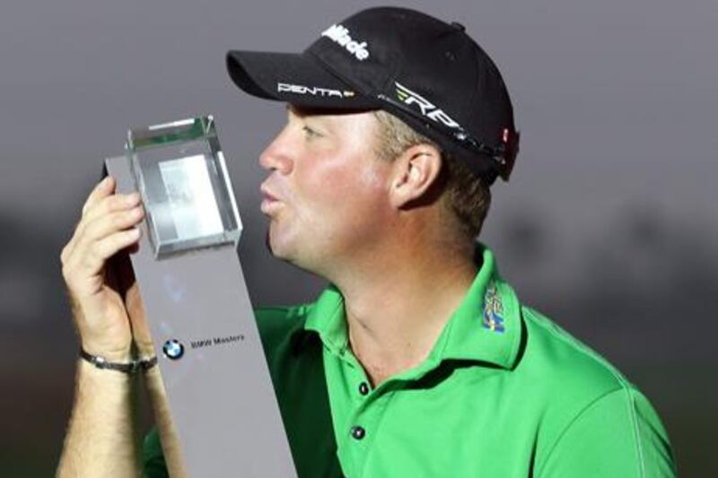 Swedish golfer Peter Hanson celebrates with the BMW Masters trophy after his victory in Shanghai