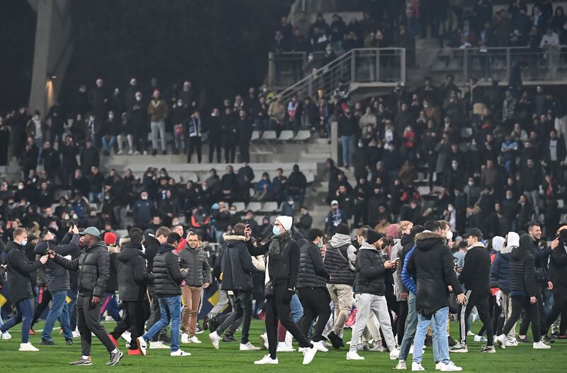Supporters walk on the pitch at half-time during the match between Paris FC and Olympique Lyonnais. AFP