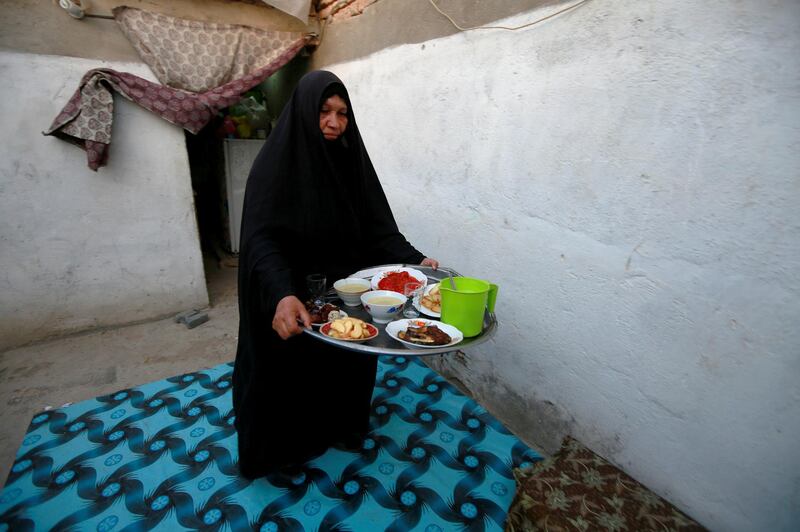 Widow Fatam Hadi Jabr, 56, carries a tray contain food to break her fast in Najaf. euters