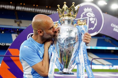Manchester City manager Pep Guardiola kisses the Premier League trophy after his side won the English Premier League following a 3-2 victory over Aston Villa at The Etihad Stadium, Manchester, England, Sunday, May 22, 2022.  (Martin Rickett / PA via AP)