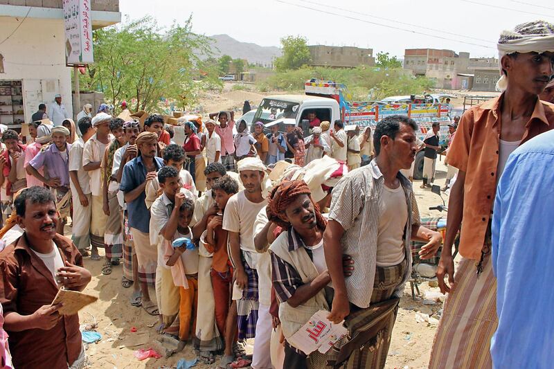 Displaced Yemenis from Hiran, in the border area with Saudi Arabia, receive food aid from Red Crescent operatives in the northern district of Abs in Hajjah province. AFP