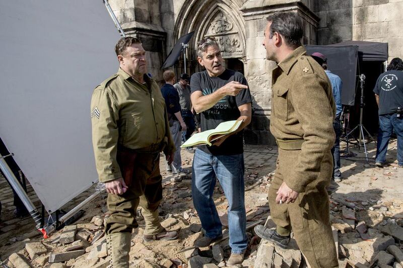 John Goodman, left, the actor and director George Clooney and Jean Dujardin, right, on the set of The Monuments Men. Courtesy Claudette Barius / AP Photo/ Columbia Pictures