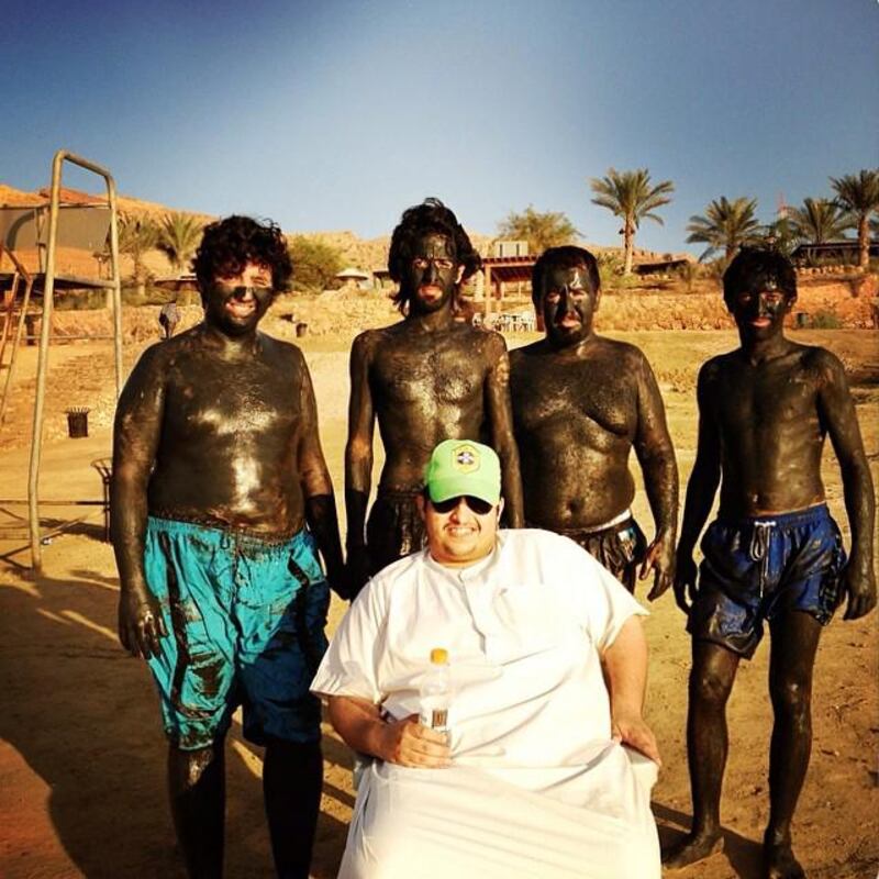 Mud-caked visitors pose for a photo next to the Dead Sea in Jordan. Photo by Newsha Tavakolian (@newshatavakolian).